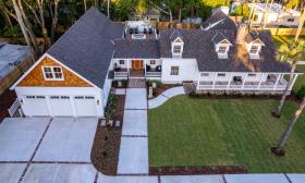 Seen from above, this expanded old home now has a large driveway, ramp, garage, and porches