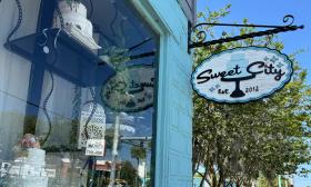 The Sweet City sign hanging outside the storefront
