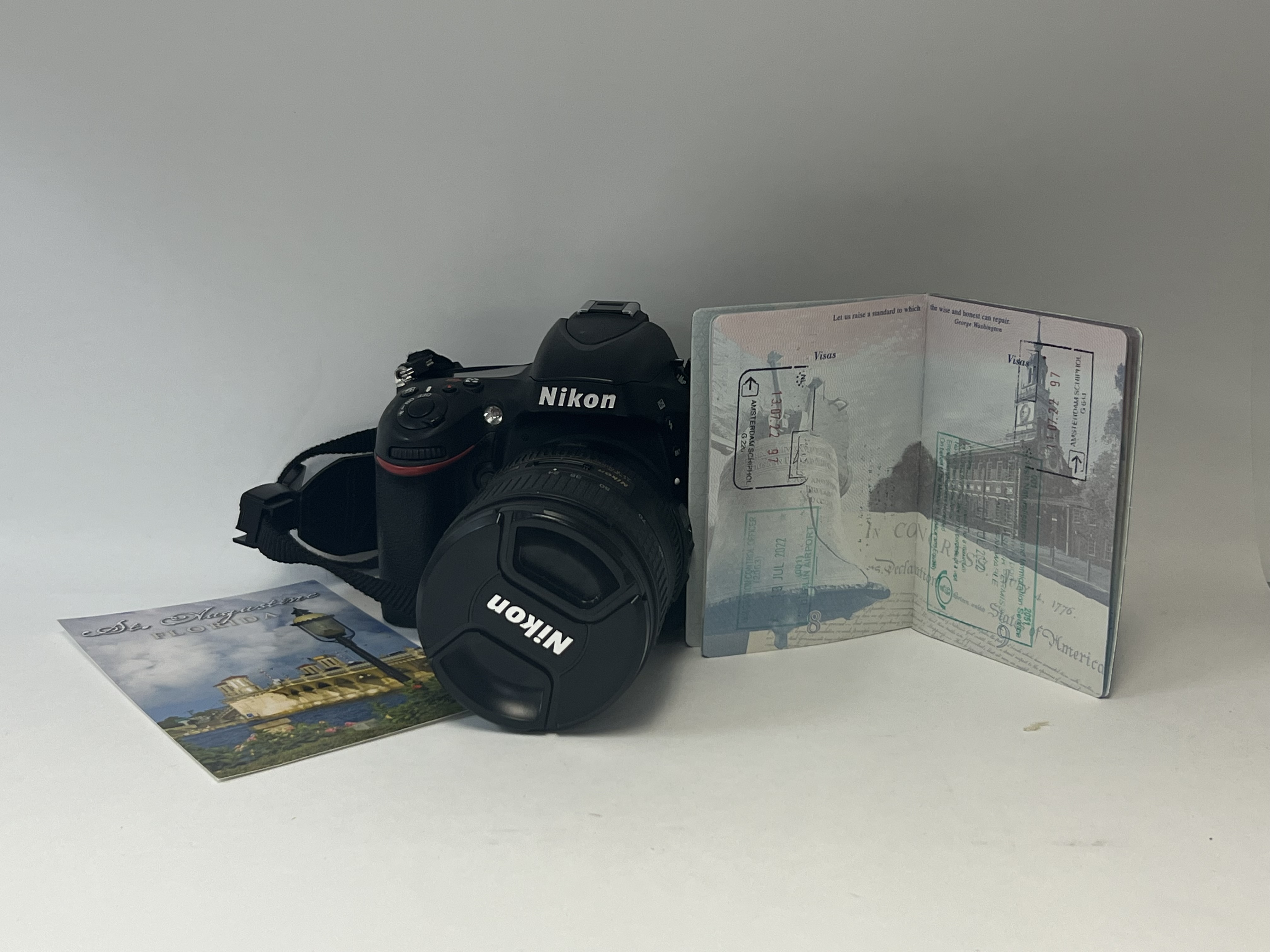 Camera with an open passport and postcard still life