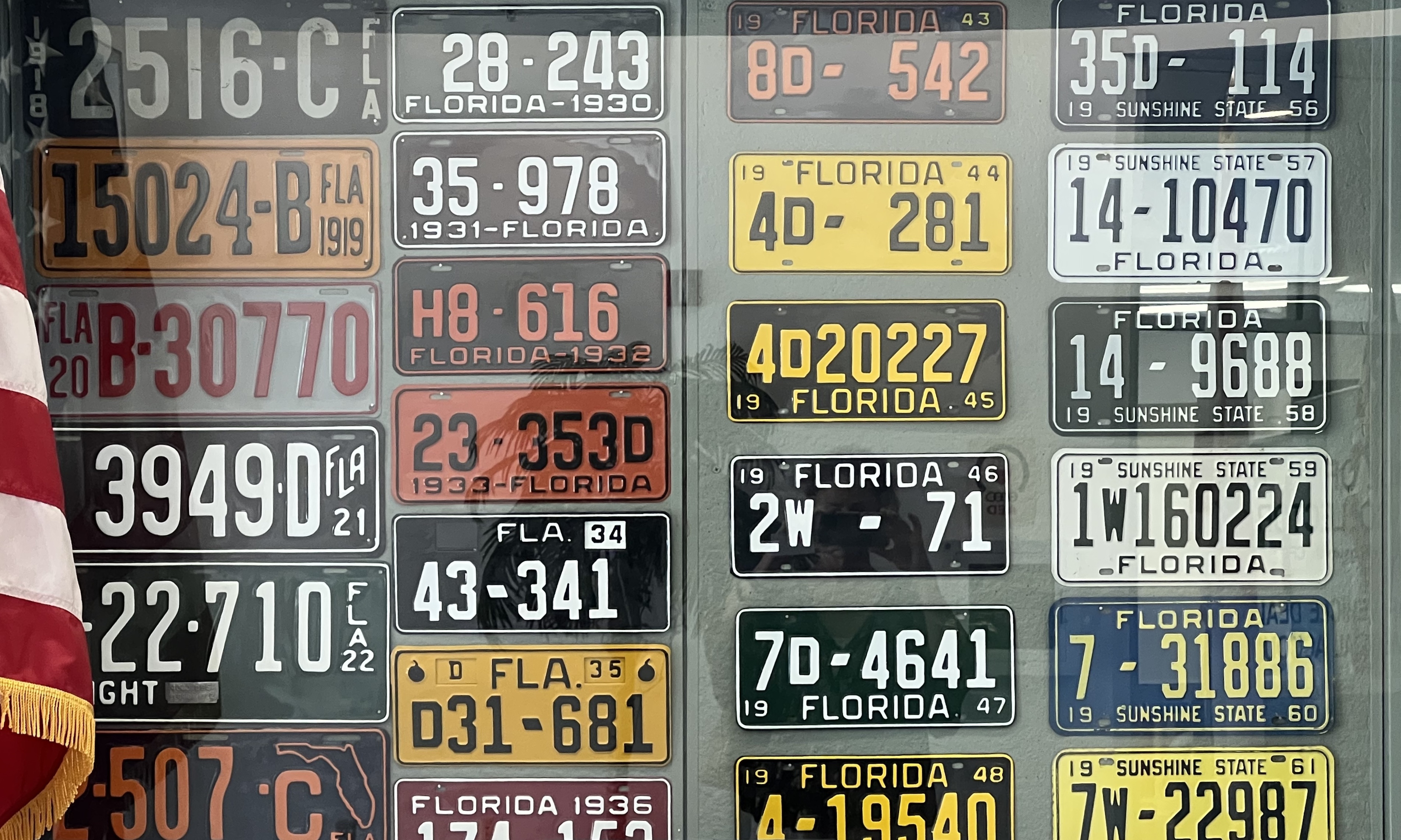 Vintage license plate display with American flag in left-hand corner