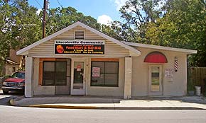 A photograph of the Korner Market in Lincolnville, St. Augustine, Florida. It is a beige one-story building facing Martin Luther King Jr. Avenue in St. Augustine. It has a bright orange and black sign out front.