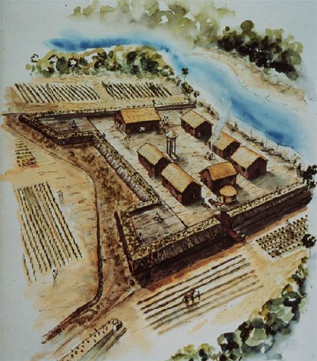 An artist's interpretation of what Fort Mose might have looked like in 1738. It is a wooden military fortification with several buildings within the walls. A marsh river flows in the background of the drawing. 