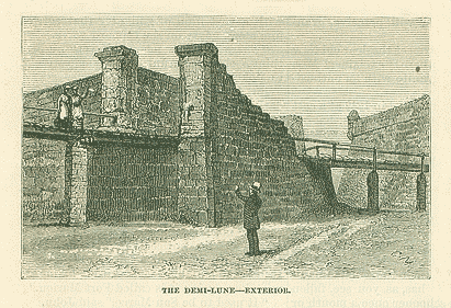 A black and white print of the lunette / demi-lune / bartizan of the Castillo de San Marcos. It is s stone fortification with a walk way. The draw bridge is visible in the background — two figures stand atop the stone walkway and one male figure stands on the ground, looking up.