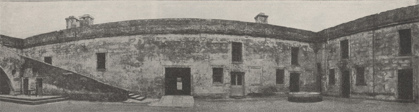 A black and white panoramic image of the interior walls of the Castillo de San Marcos in St. Augustine, Florida, circa 1915. This shows the east facing wall of the inner courtyard on the north side of the image and the west facing wall on the left side of the image..