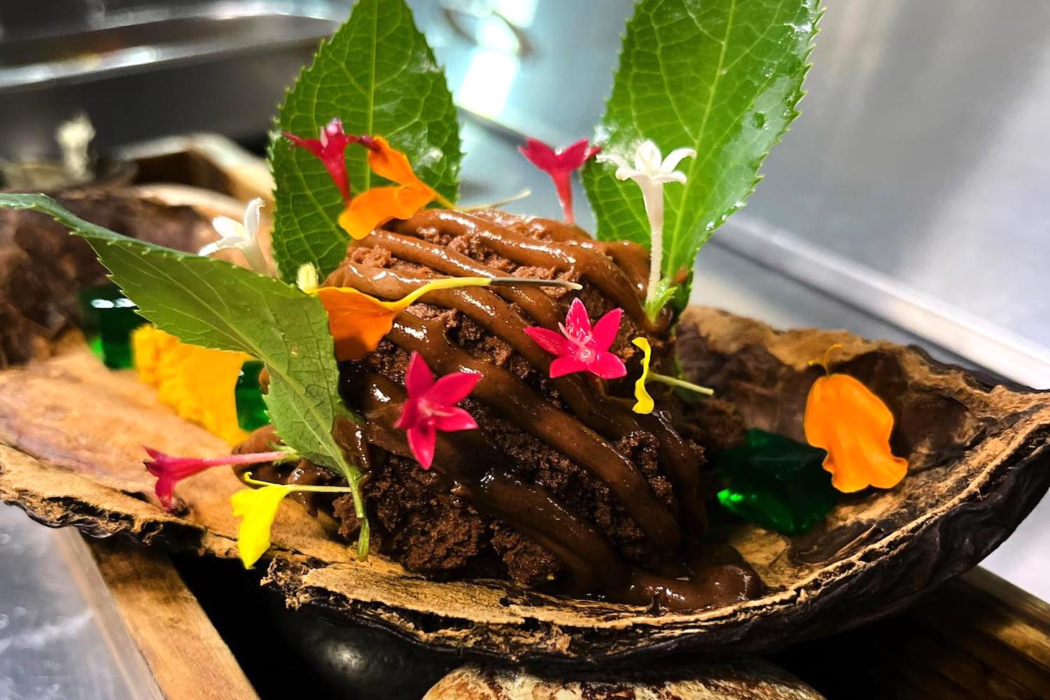 Quillabamba cacao mousse and Lucuma fruit puree, drizzled with spiced chocolate sauce and garnished with burnt Urubamba Eucalyptus at Llama Restaurant.