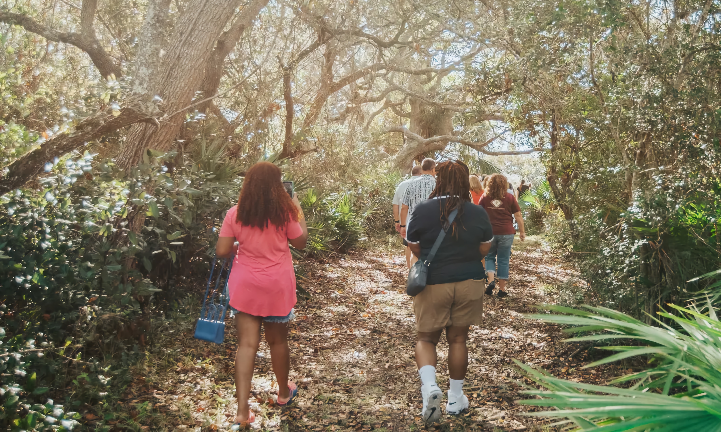 A group of people walking along a trail at GTMR in Ponte Vedra