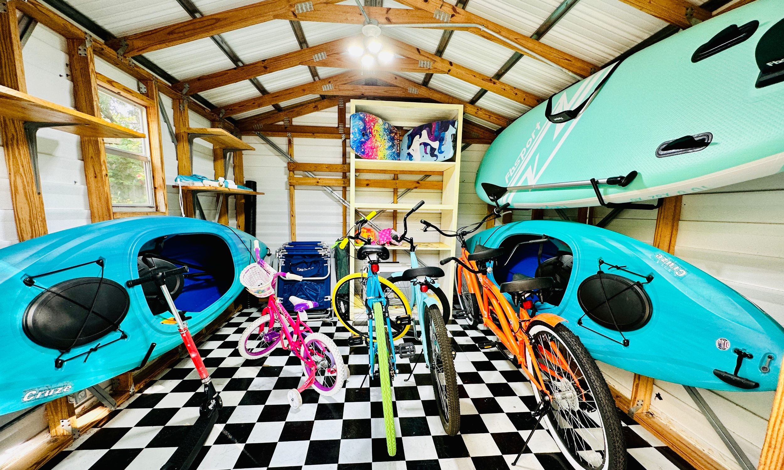 Brightly colored bikes kayaks, and a SUP, are ready in the outdoor storage area at Paraiso in Vilano