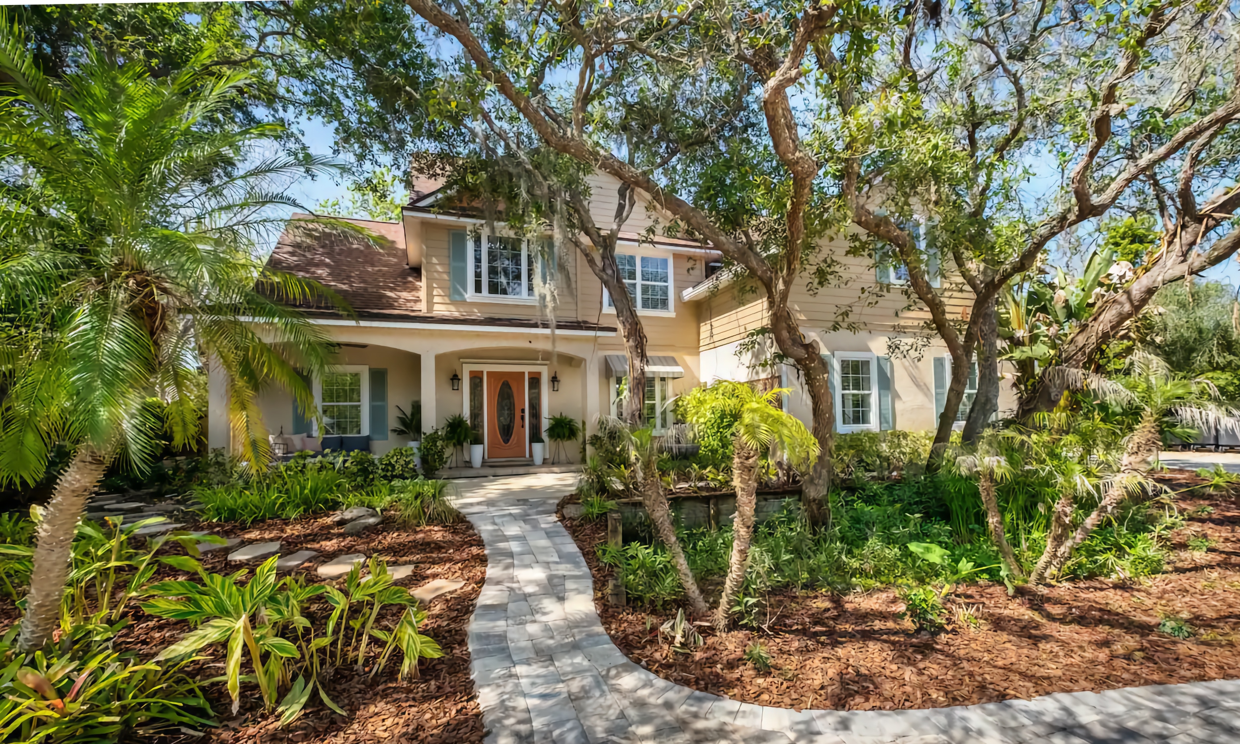 The Paraiso in Vilano, a luxury vacation rental, set among mature plants, with a paved walk.