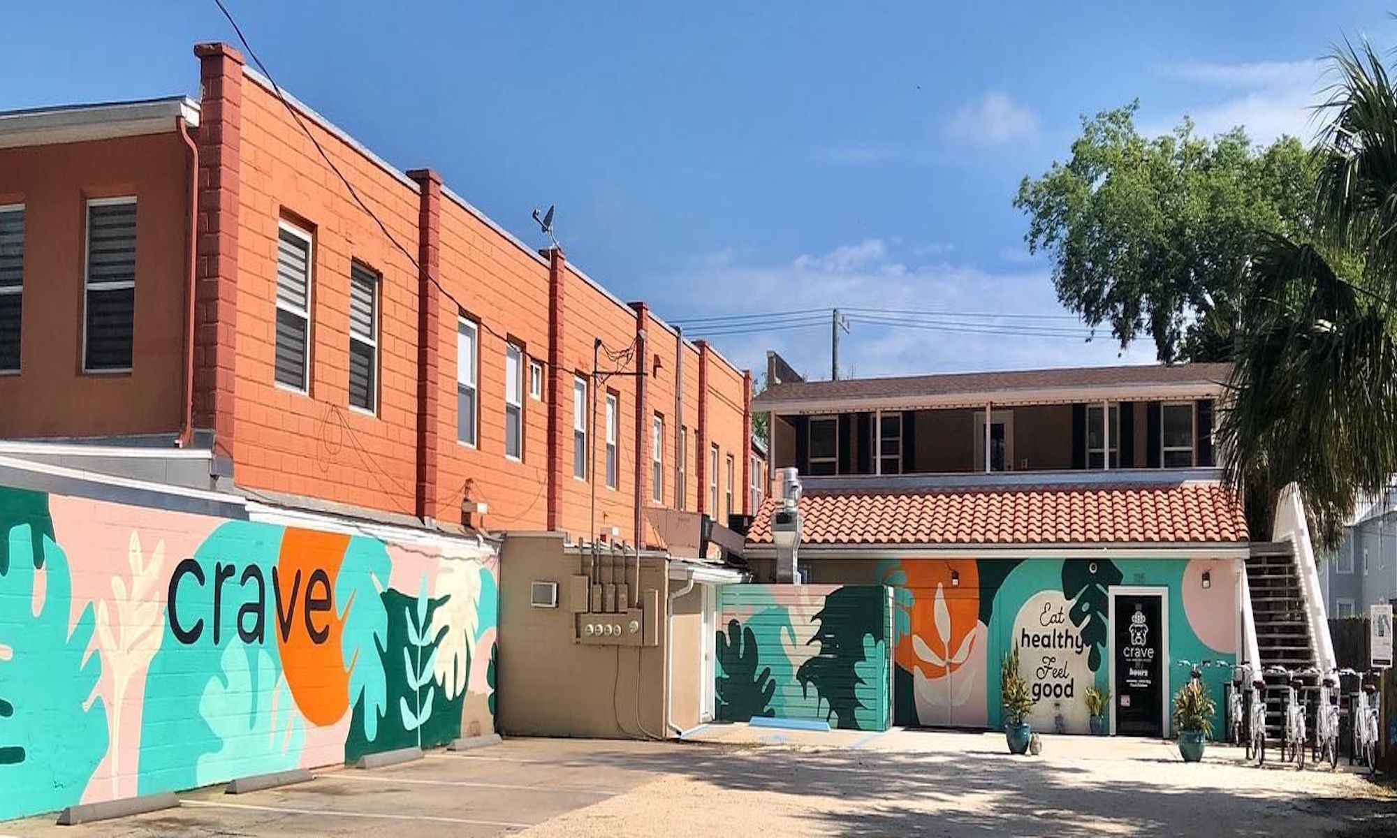 Crave parking lot with mural, bikes, and back door