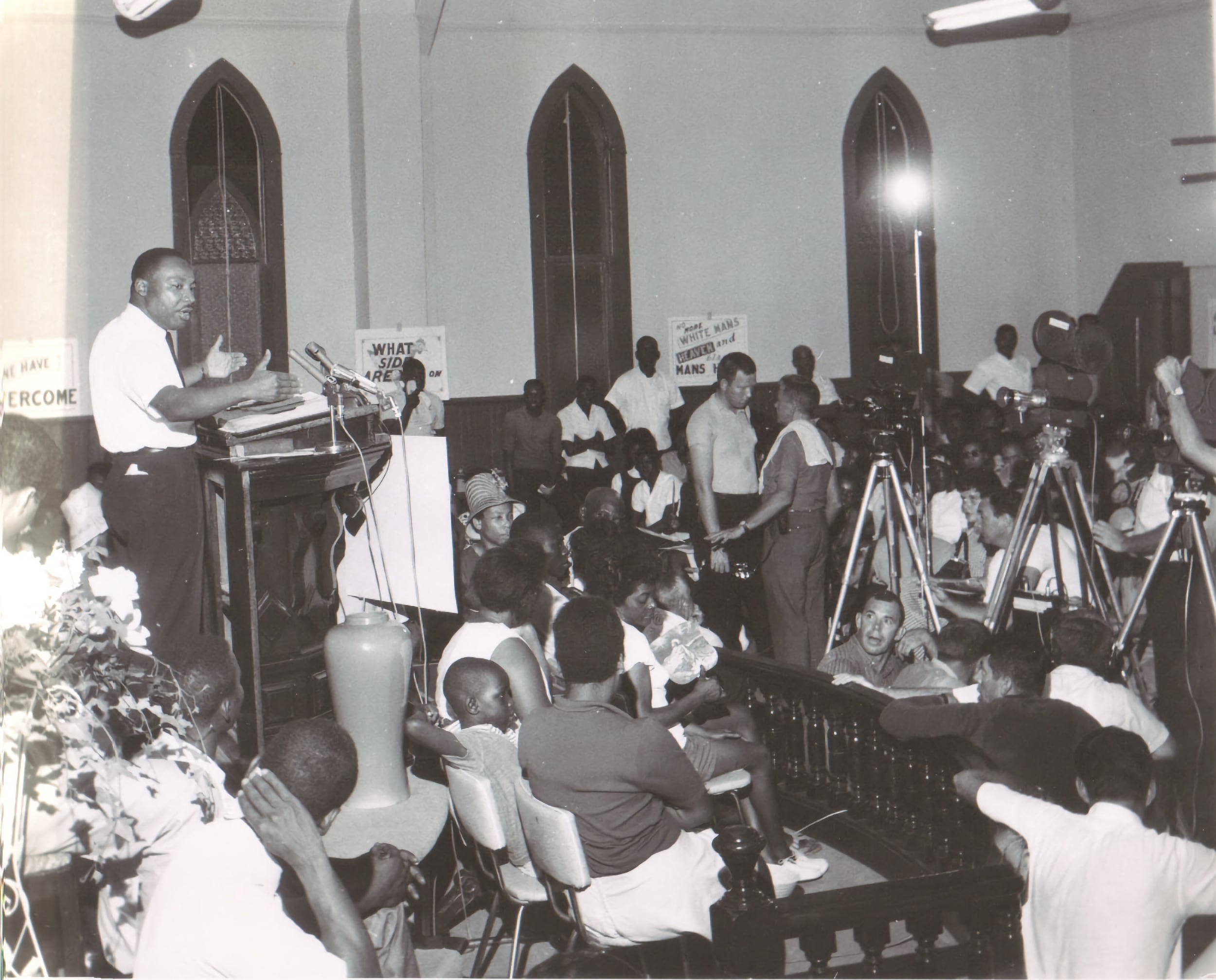 B&W Dr. MLK Jr. stands at a podium at St. Paul SME Church, speaking to a group of supporters.