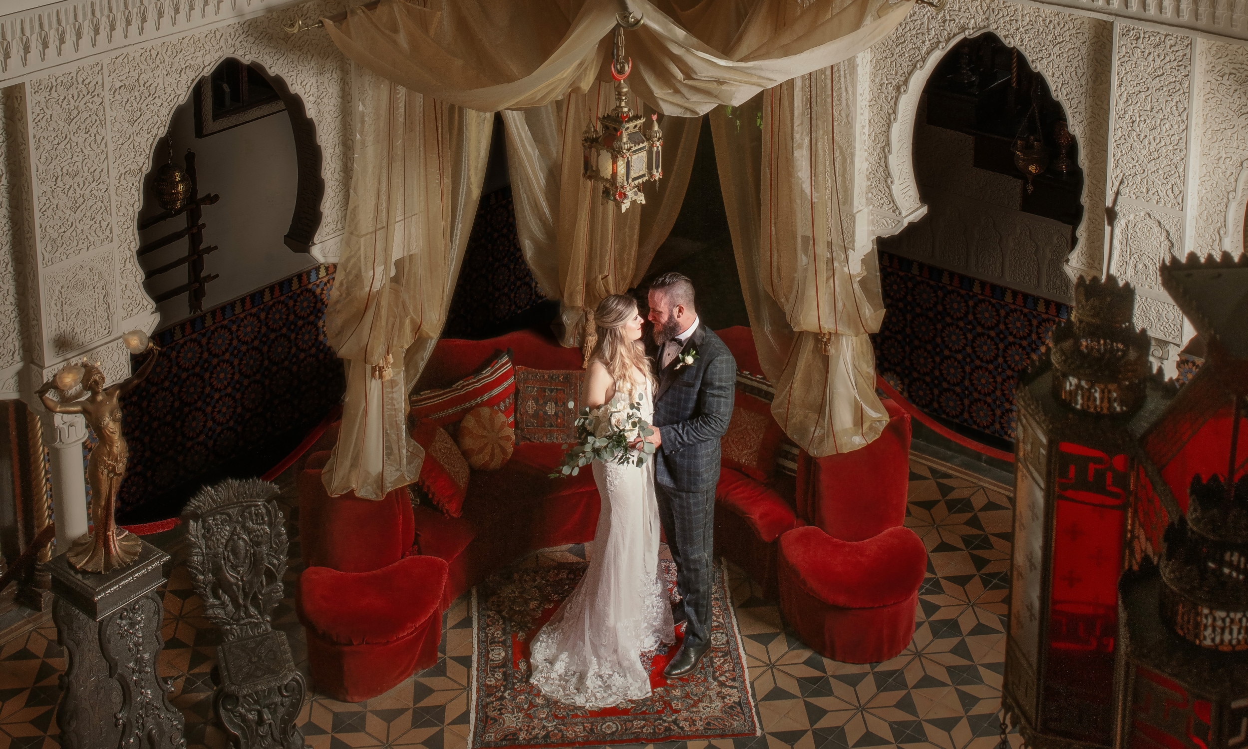 A bridal couple standing in Villa Zorayda's Court of Lions, surrounded by opulent decor and architectural details