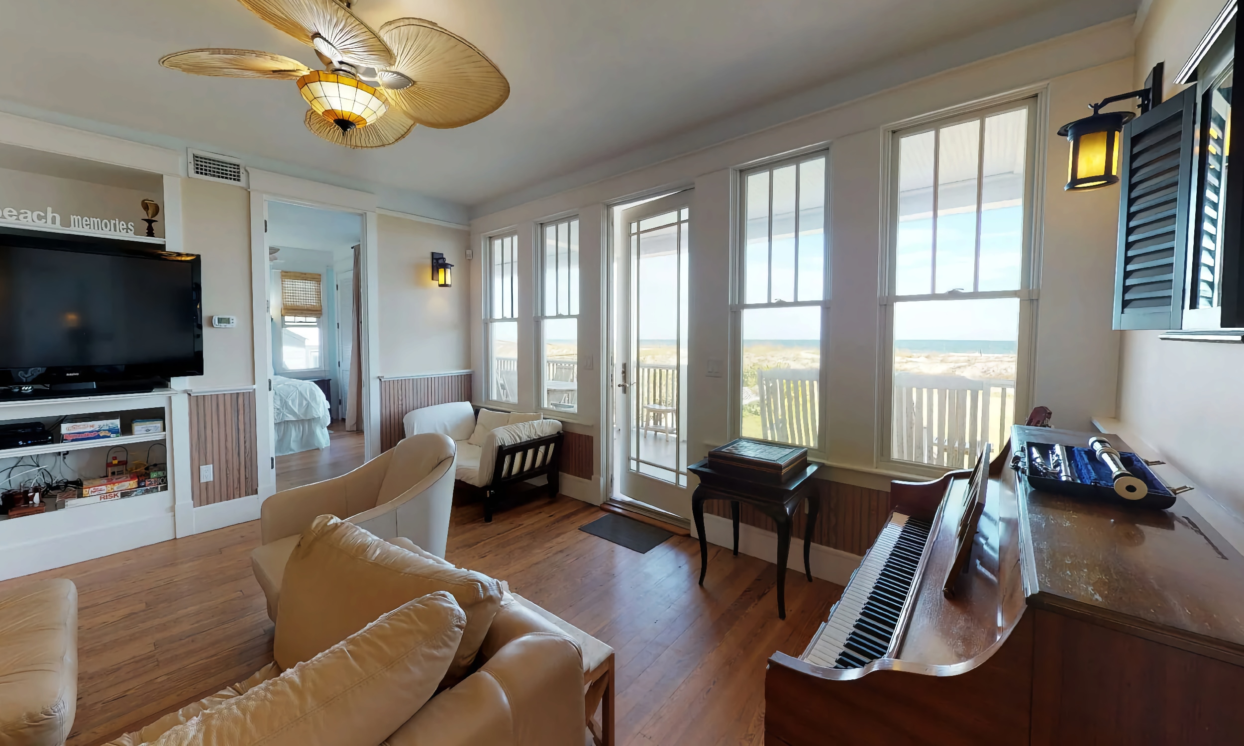 One lounge in this large vacation home has a piano and a view of the ocean