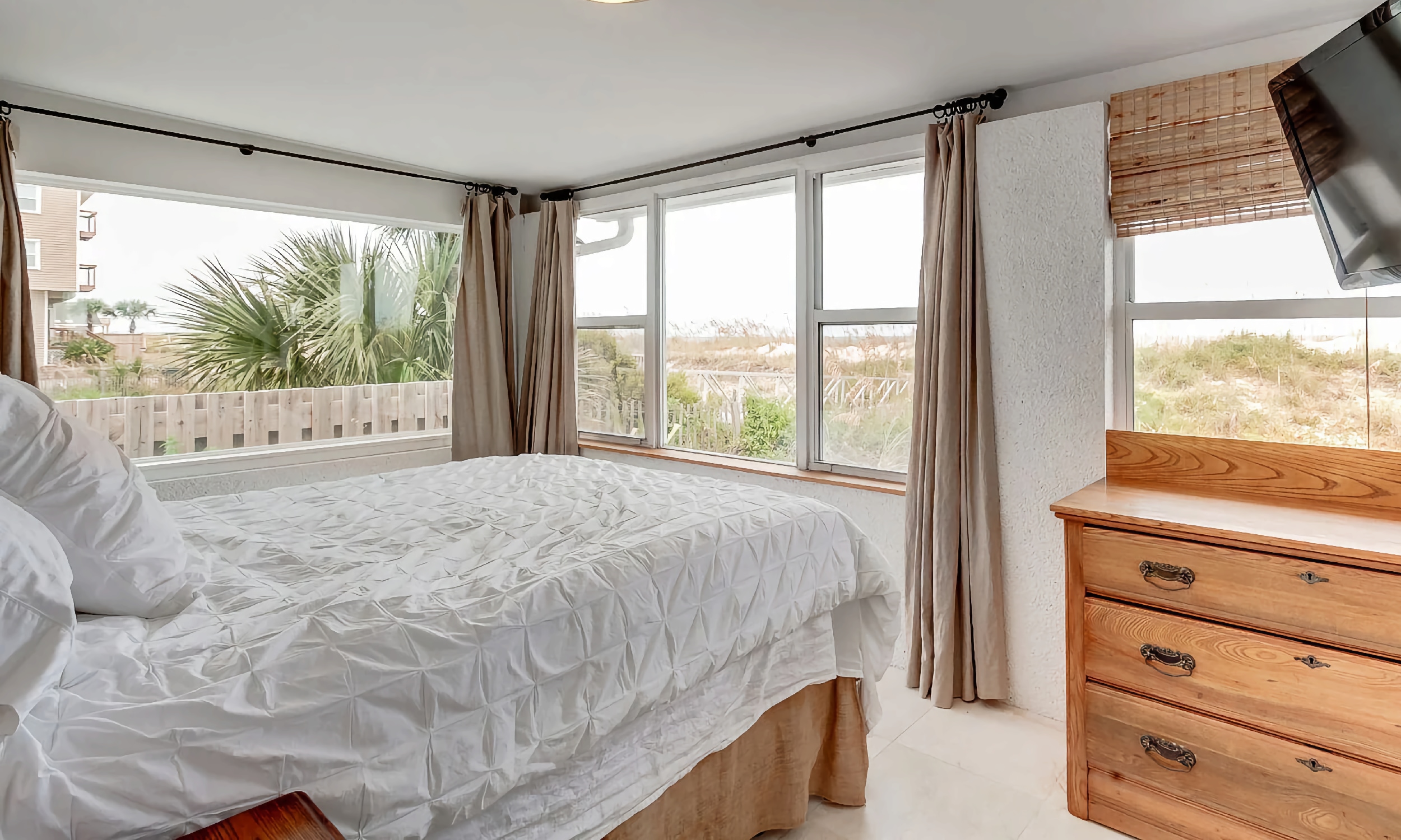 A bedroom on St. Augustine Beach has a view of the dunes and the Atlantic Ocean