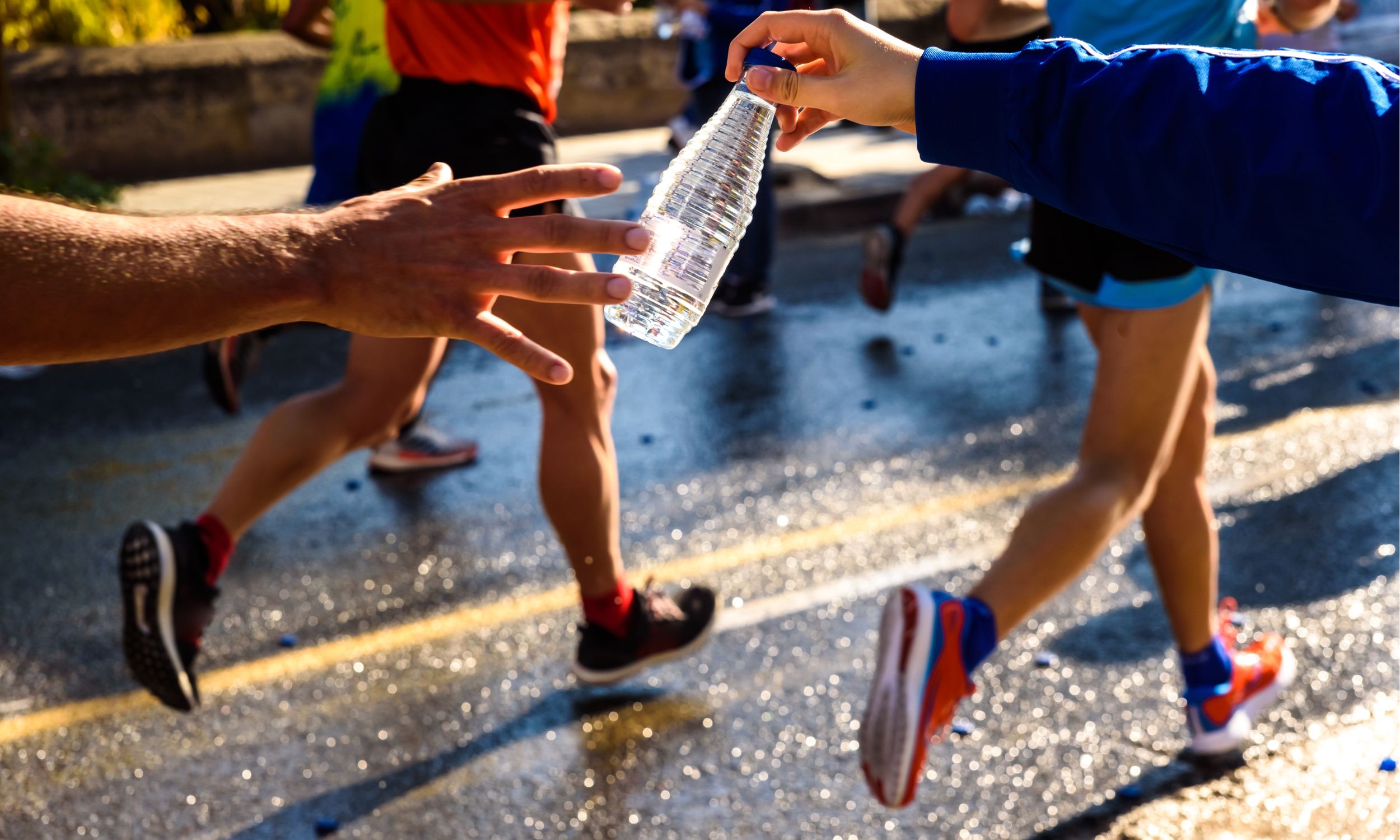 Runner grabbing a bottle of water during a race checkpoint
