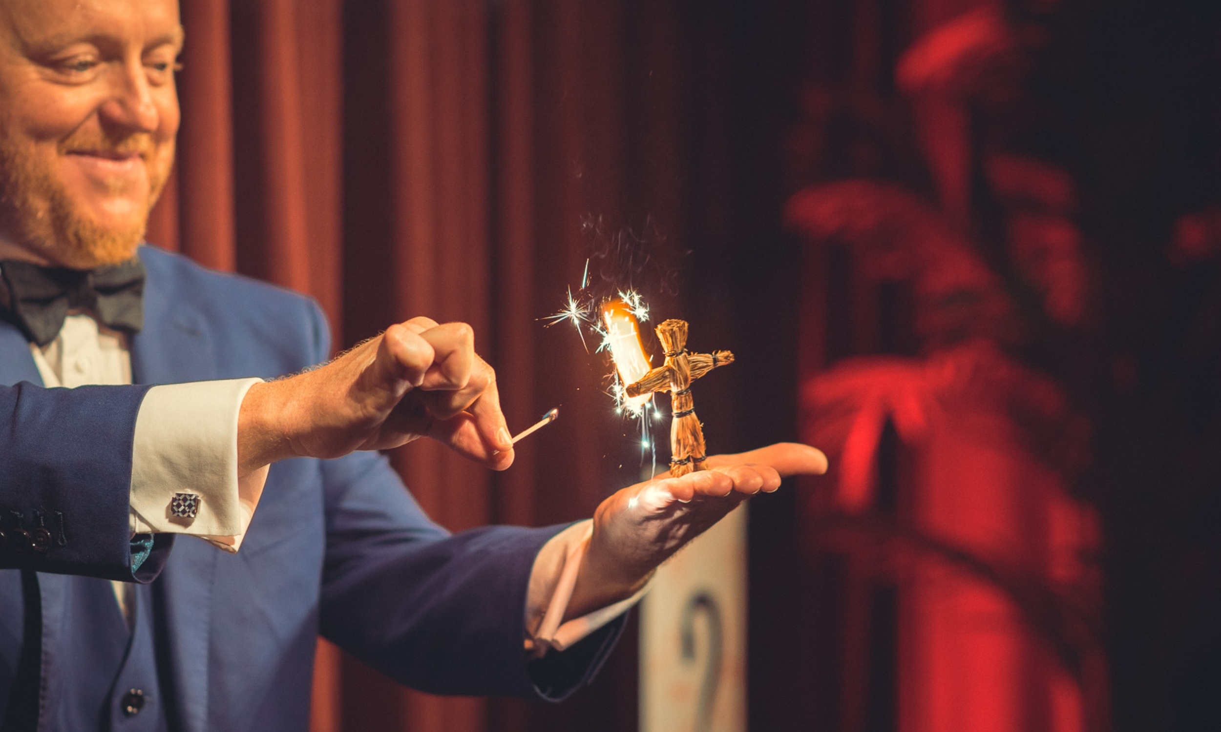 Master Magician Bill Abbott lighting a straw man that is held in his palm