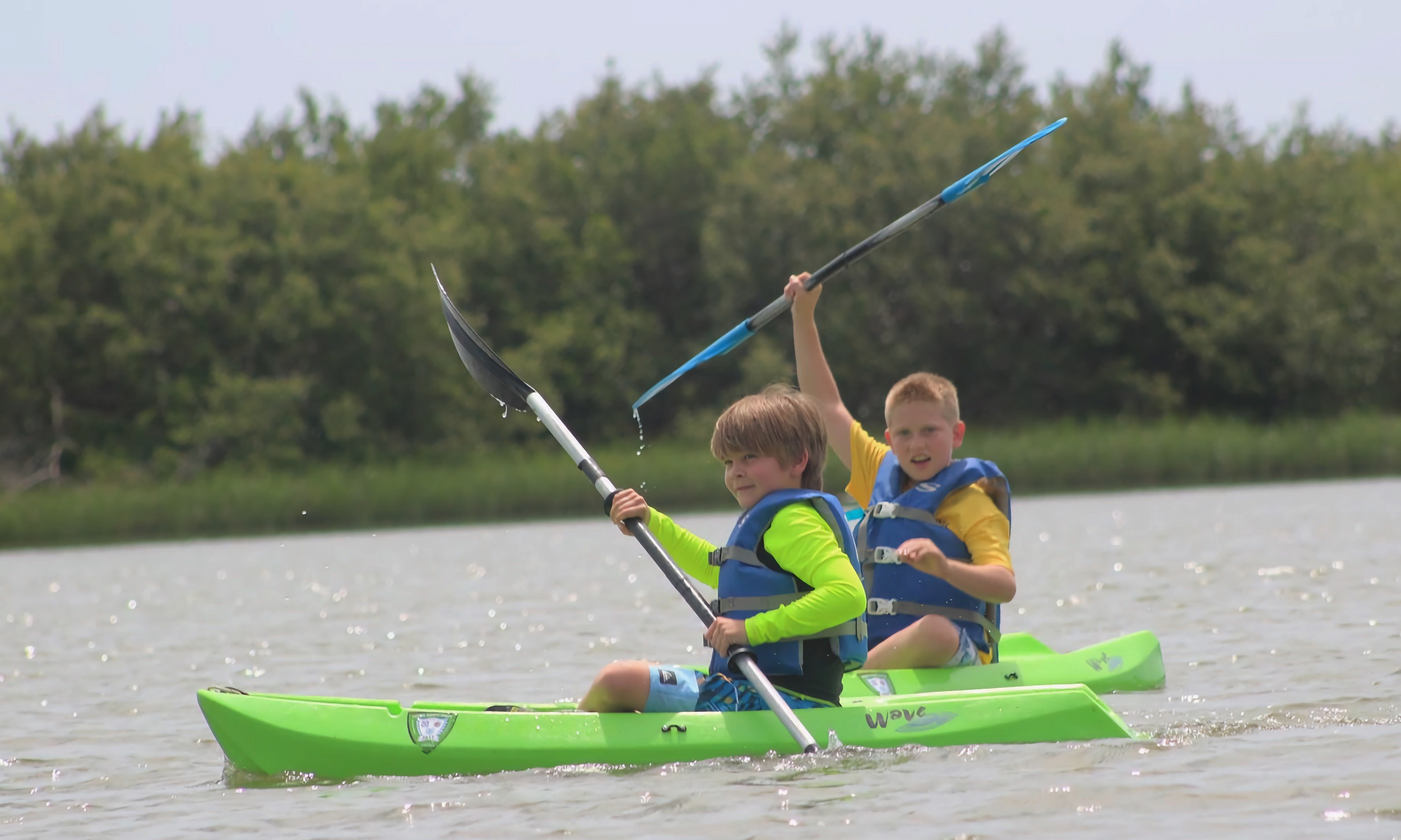 Two children kayaking on the water