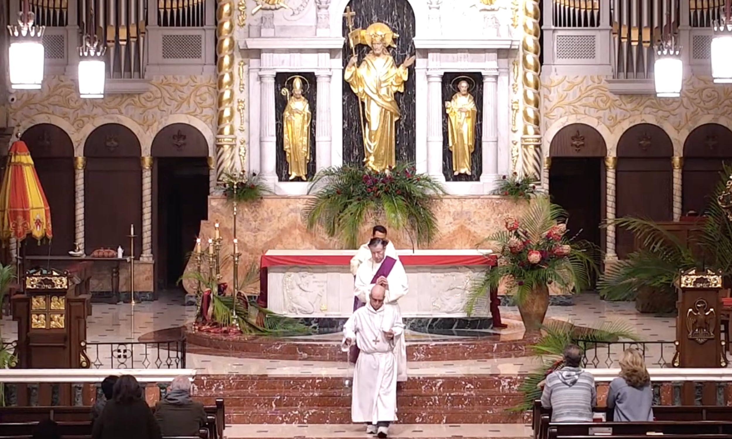 Cathedral Basilica of St. Augustine during Mass, with clergy in white vestments descending from the altar