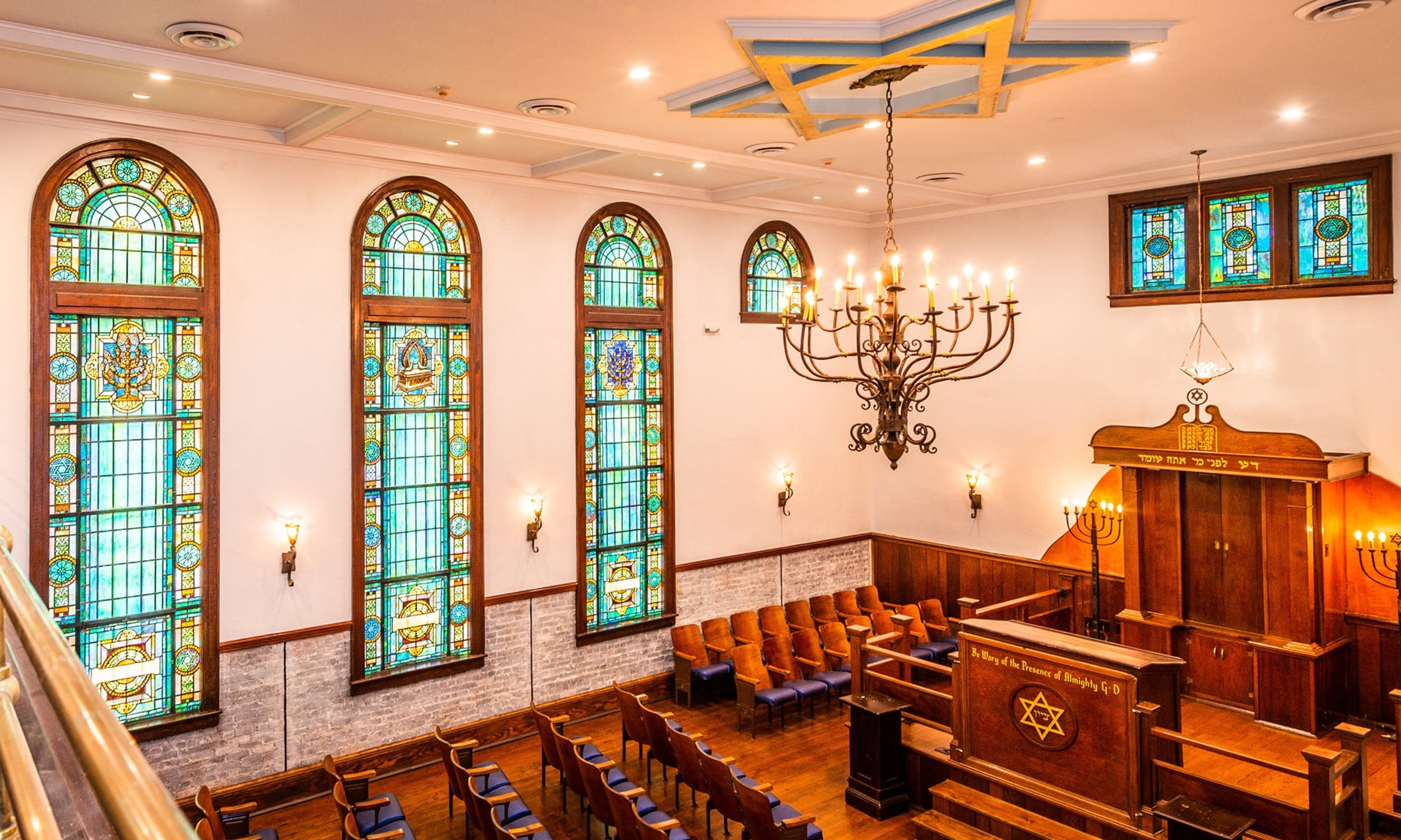 Balcon view of the stained glass windows, Star of David chandelier, and mezzanine seating at First Congregation Sons of Israel