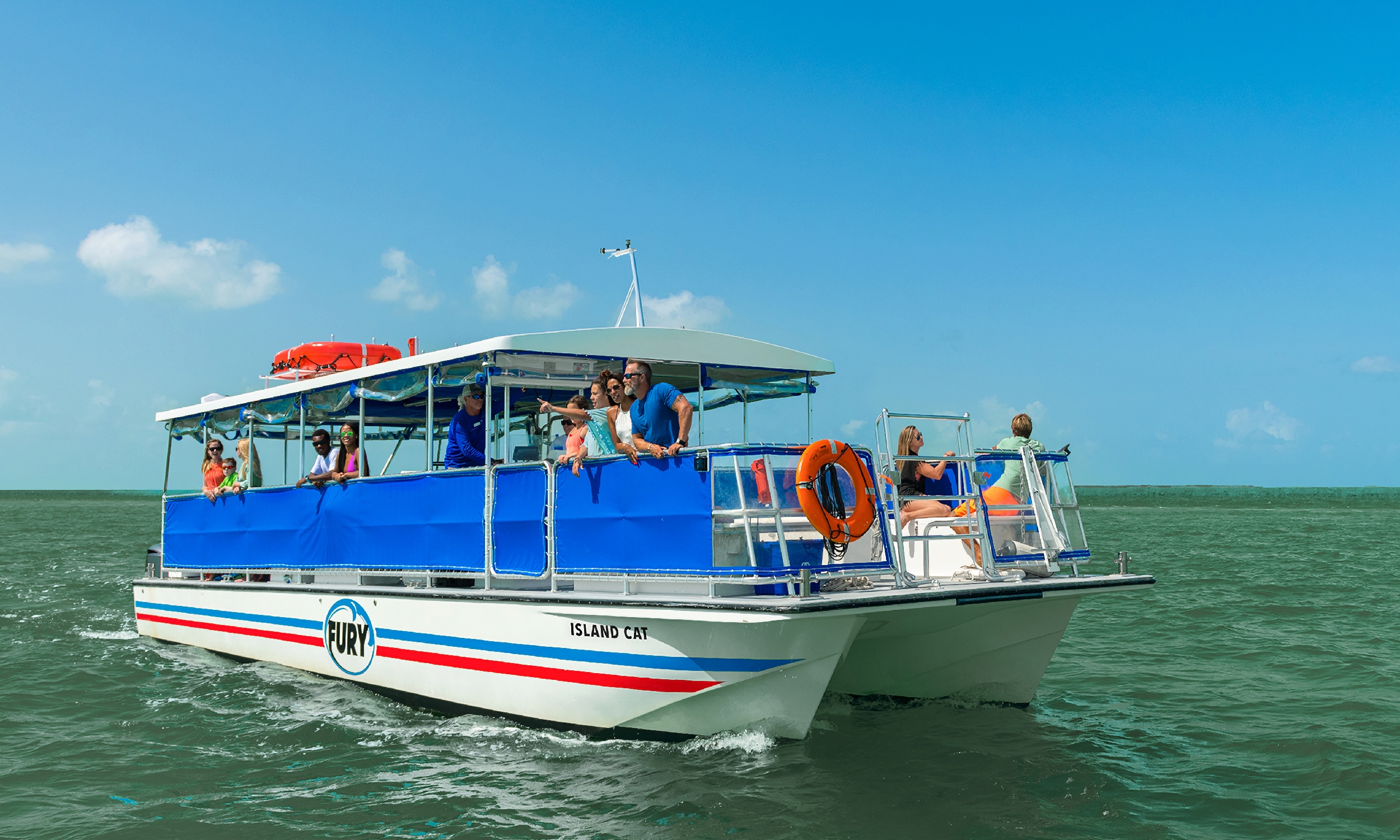 A red, white, and blue Fury power cat takes guests on the water