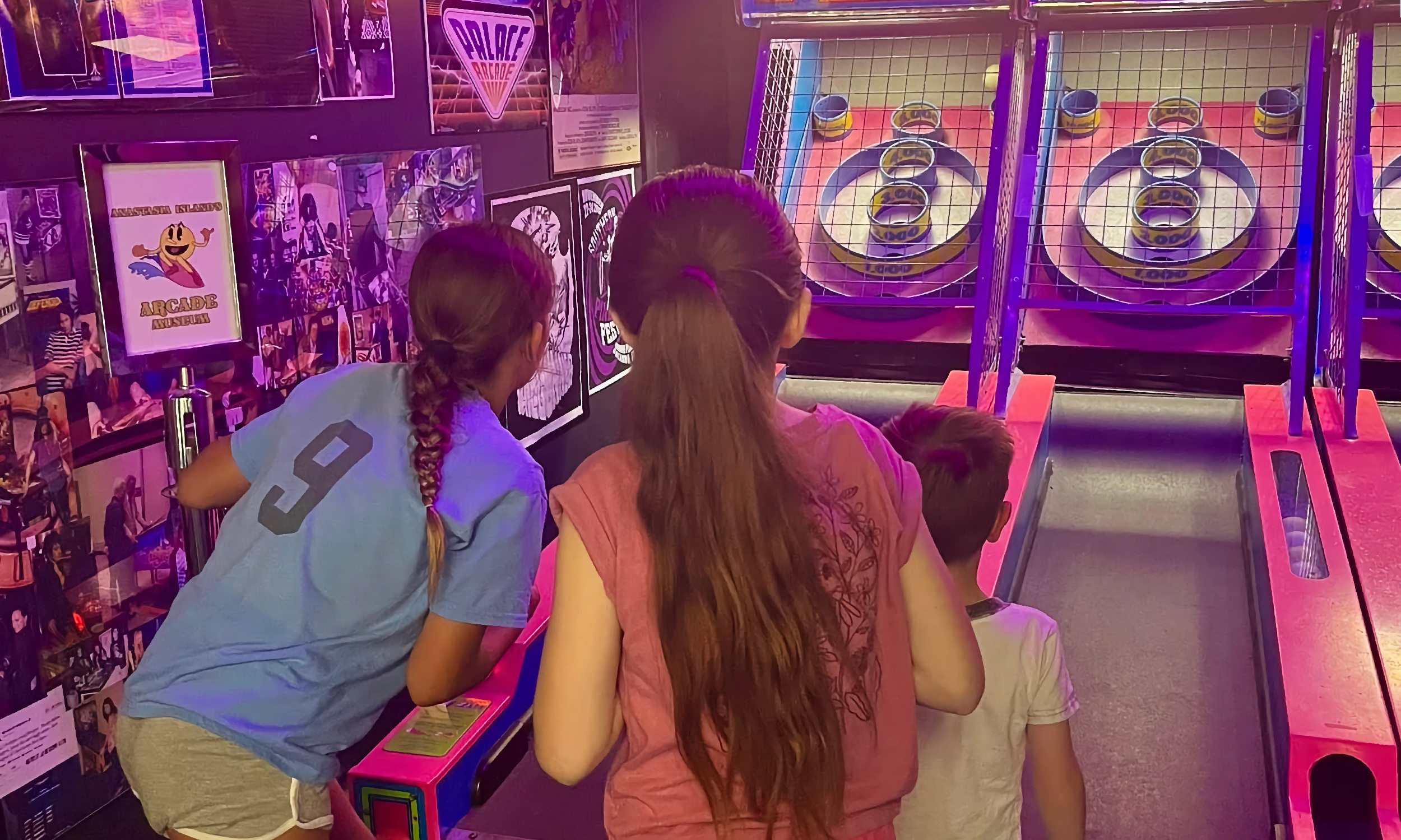 Three younsters playing an arcade game