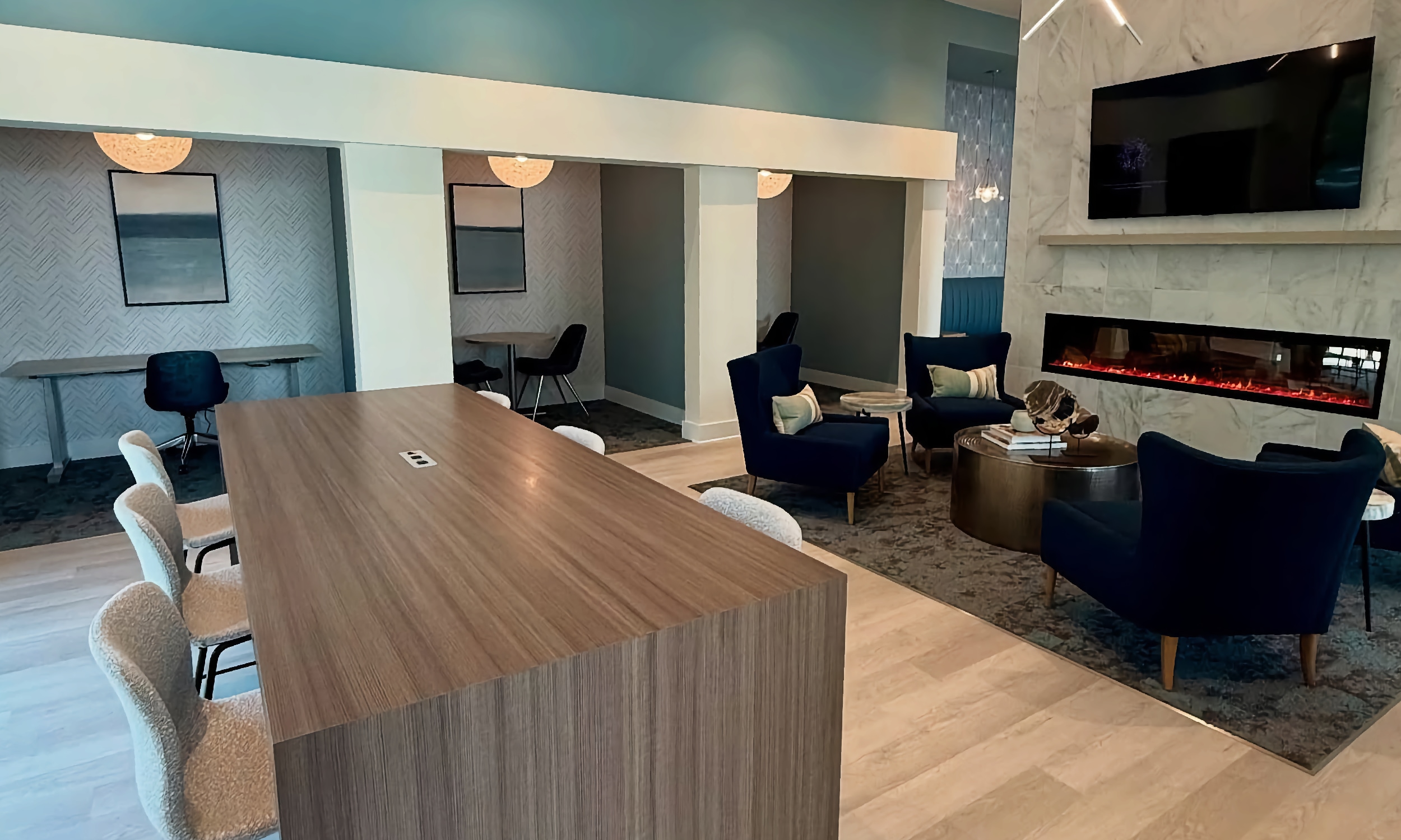 A community lounge with fireplace, and work stations at Bradley Apartments