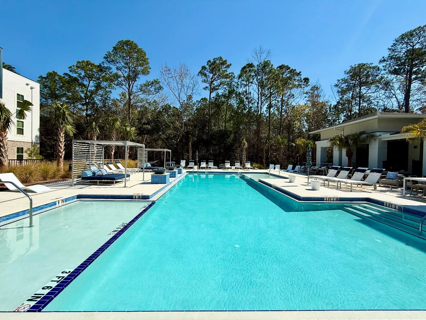 This pool at an apartment complex has cabanas and a tanning deck.
