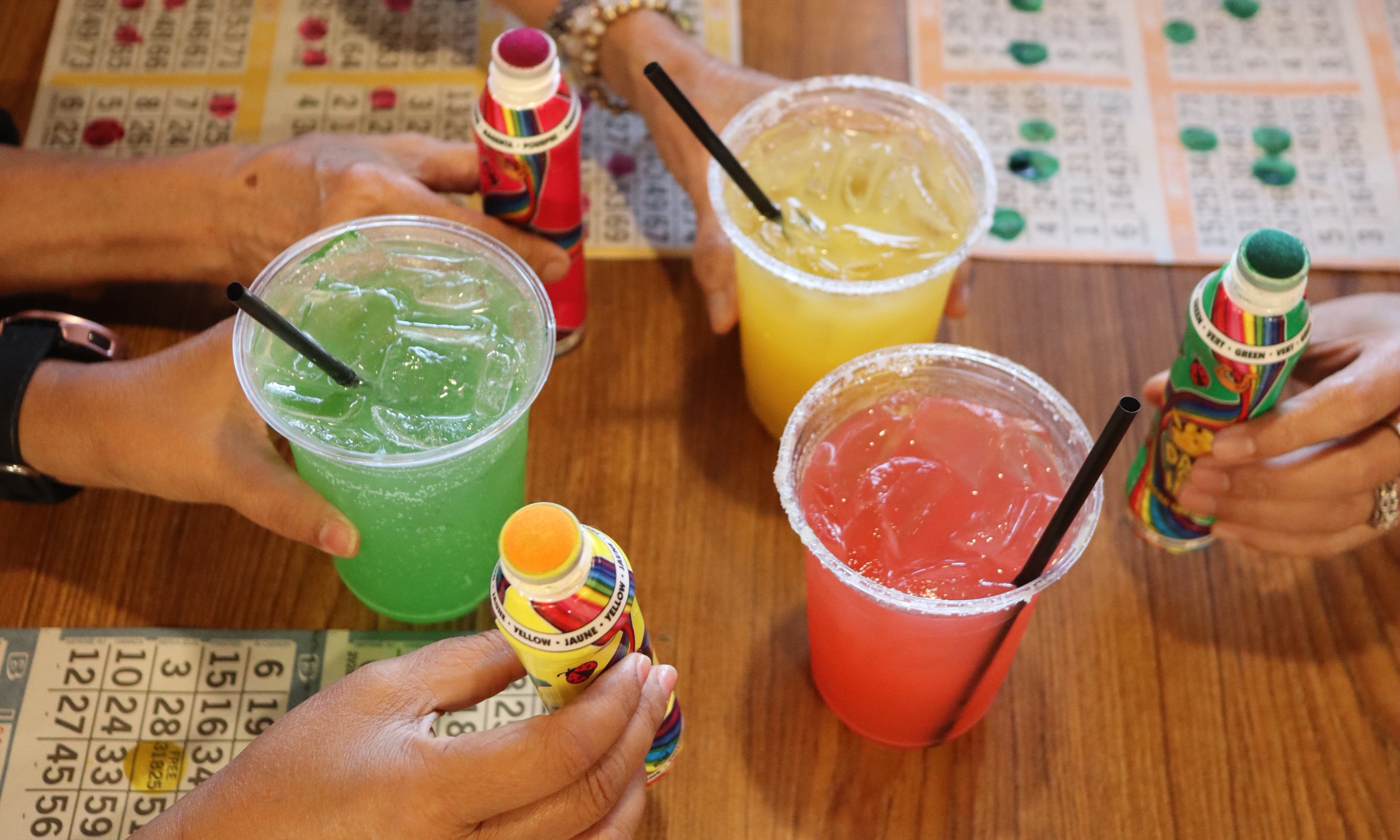 Three colorful drinks and three bingo cards