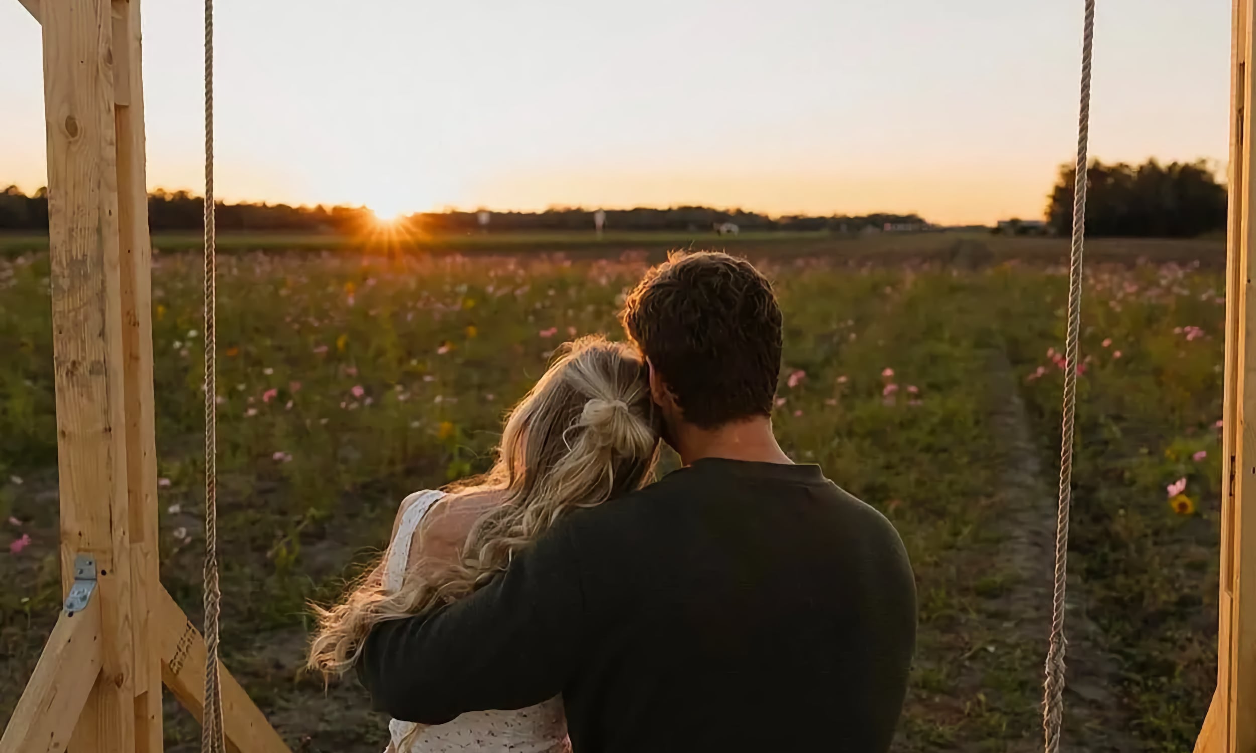 Couple watching the sunset from a swing at Parker Flower Farms