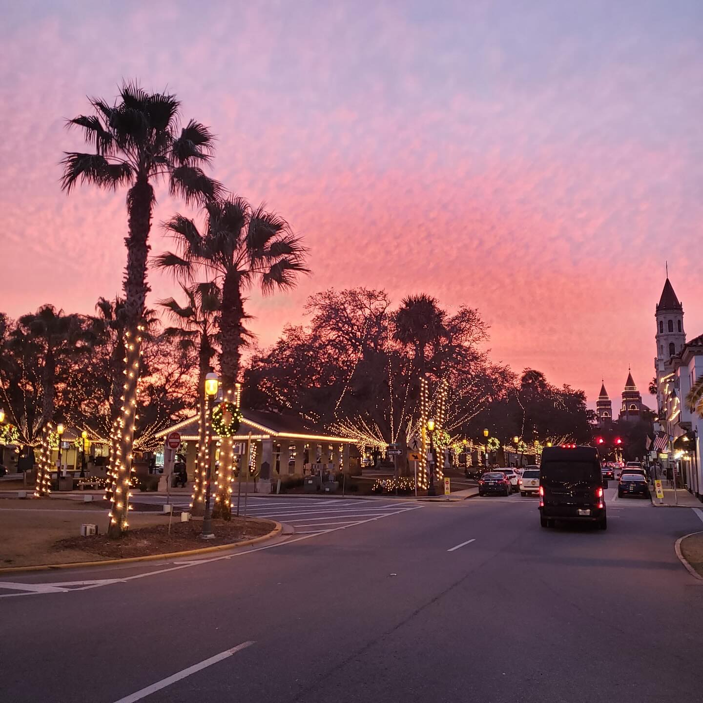 The plaza in st. Augustine, lit for Nights of Lights, at dusk under a pink sky