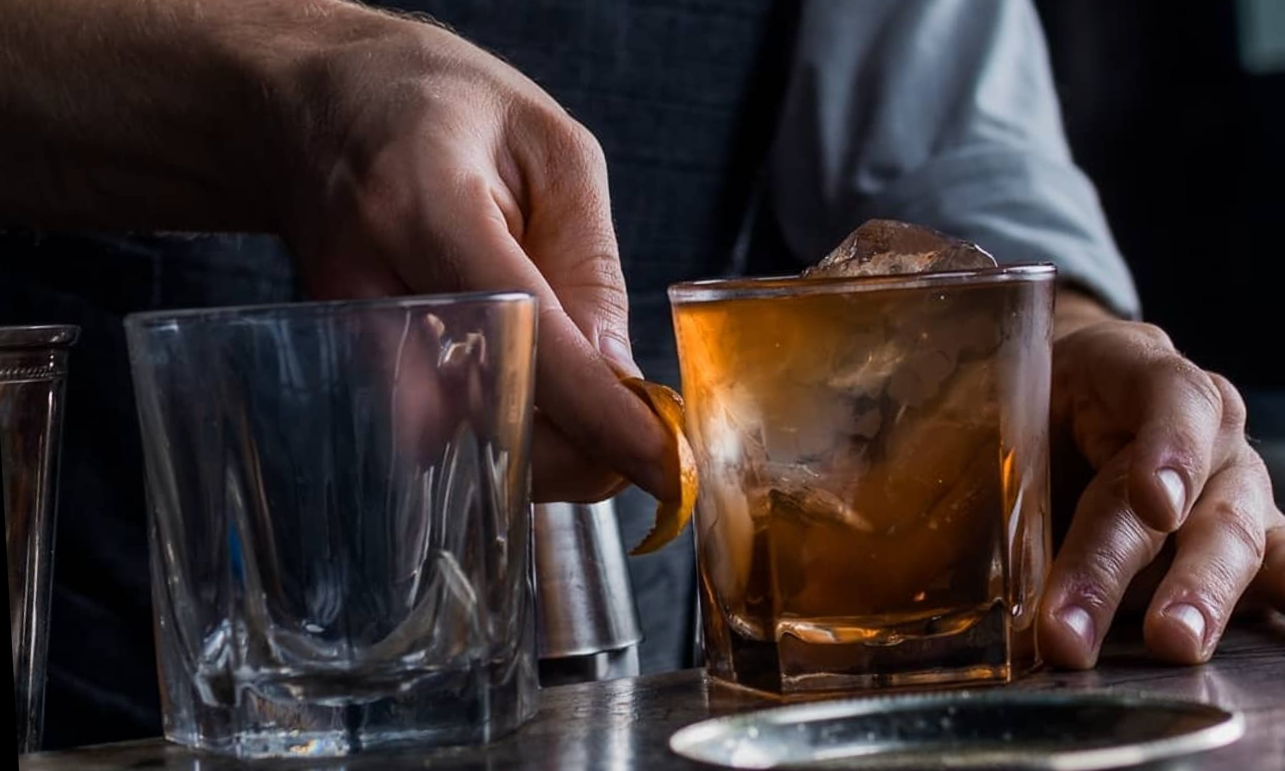 Bartender from Ice Plant Bar rubbing orange oil on the outside of a cocktail