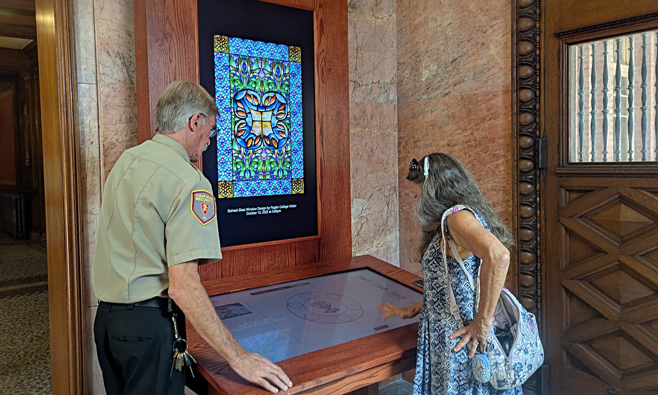 A Flagler secruity guard shows a visitor how to play with stained glass shapes and colors
