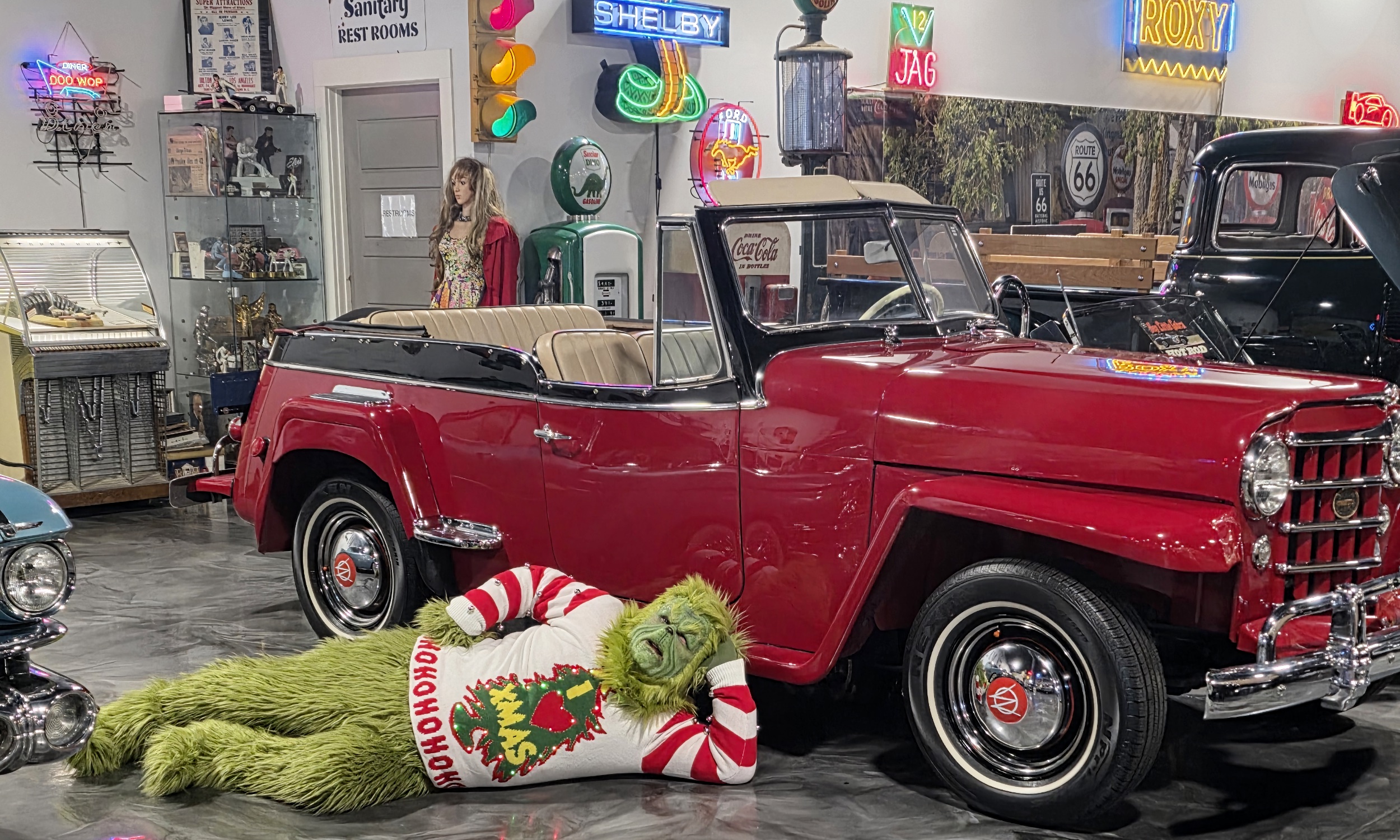 The Grinch posing in front of a classic car