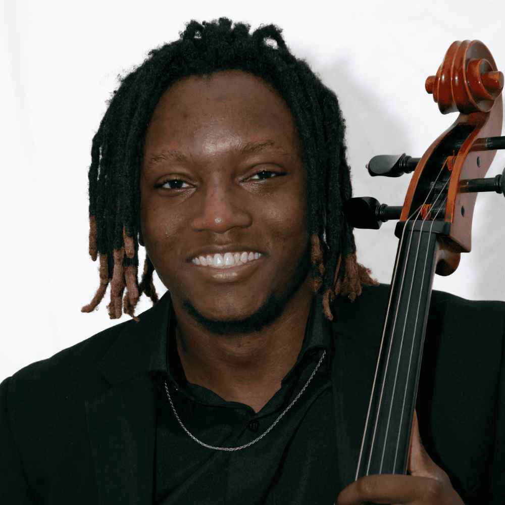 Cellist Khalil Payne with his cello against a white background