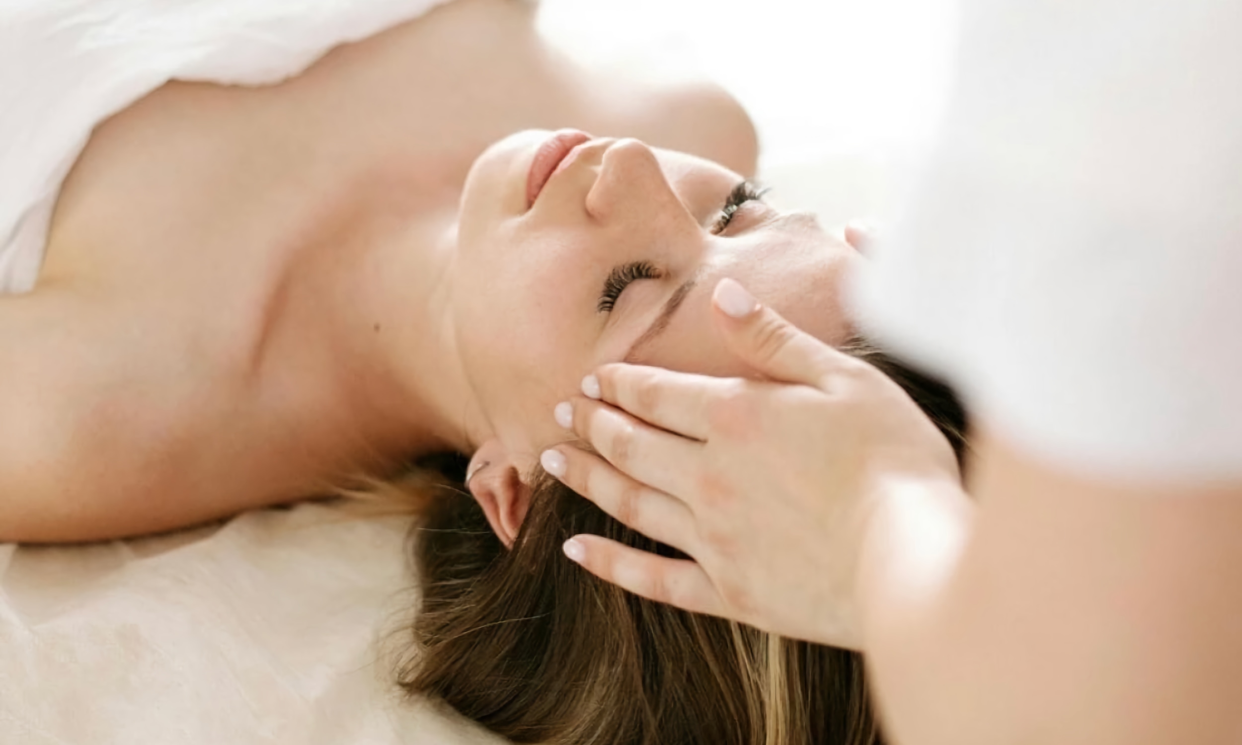A woman at a spa, relaxing during a facial treatment