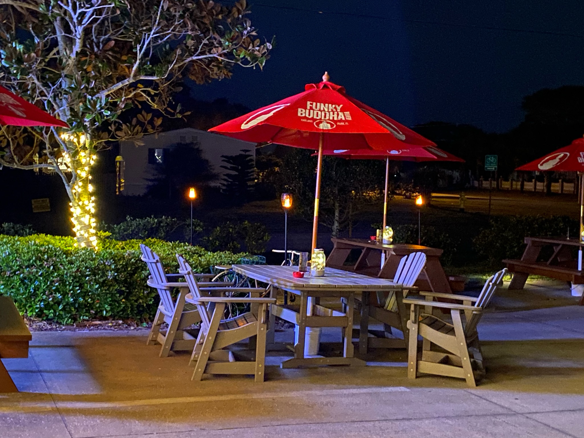 An outdoor dining table with a lighted umbrella at Back 40 A1A