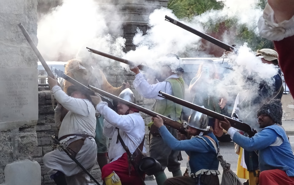 Militia members fire their guns at raiders trying to breach the wall