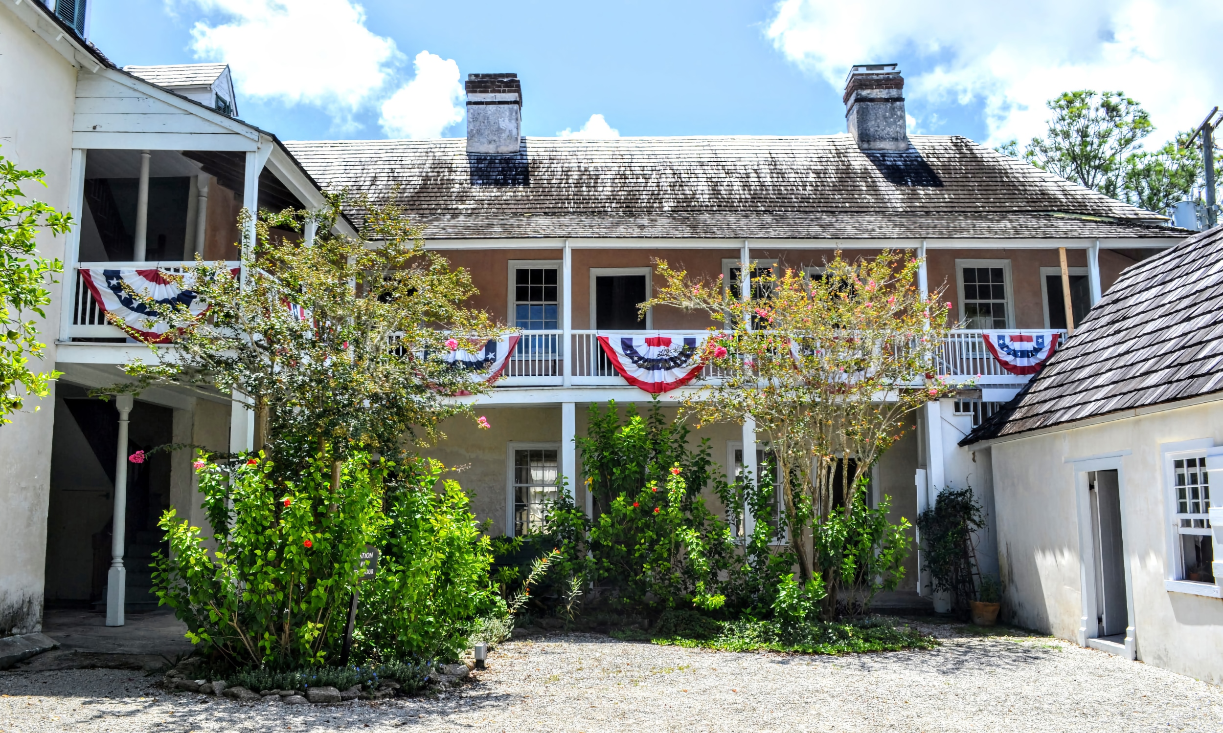 The courtyard of the Ximenez-Fatio House with patriotic bunting hanging from the balconies
