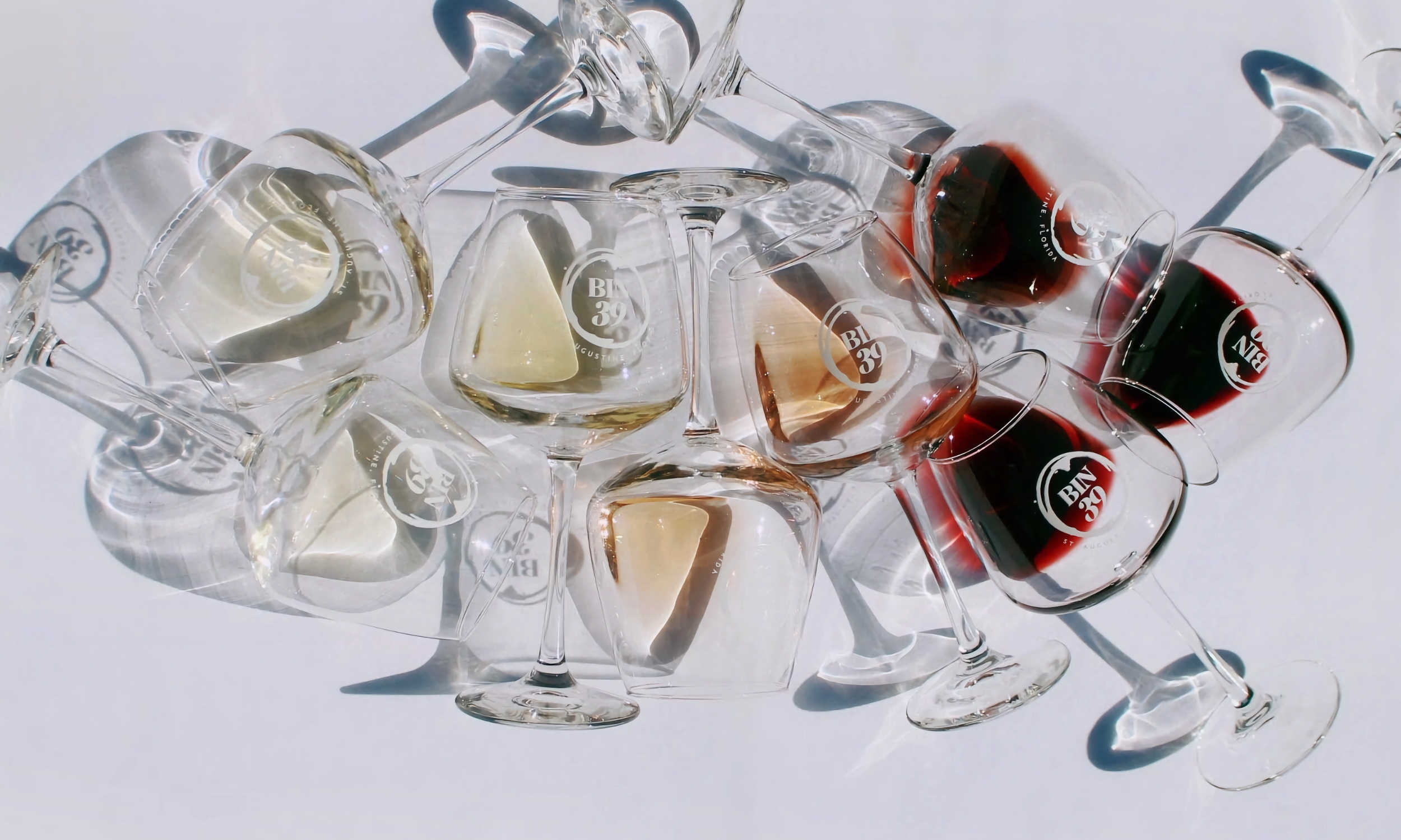 Bin 39 wine glasses on a white table in an artistic arrangement