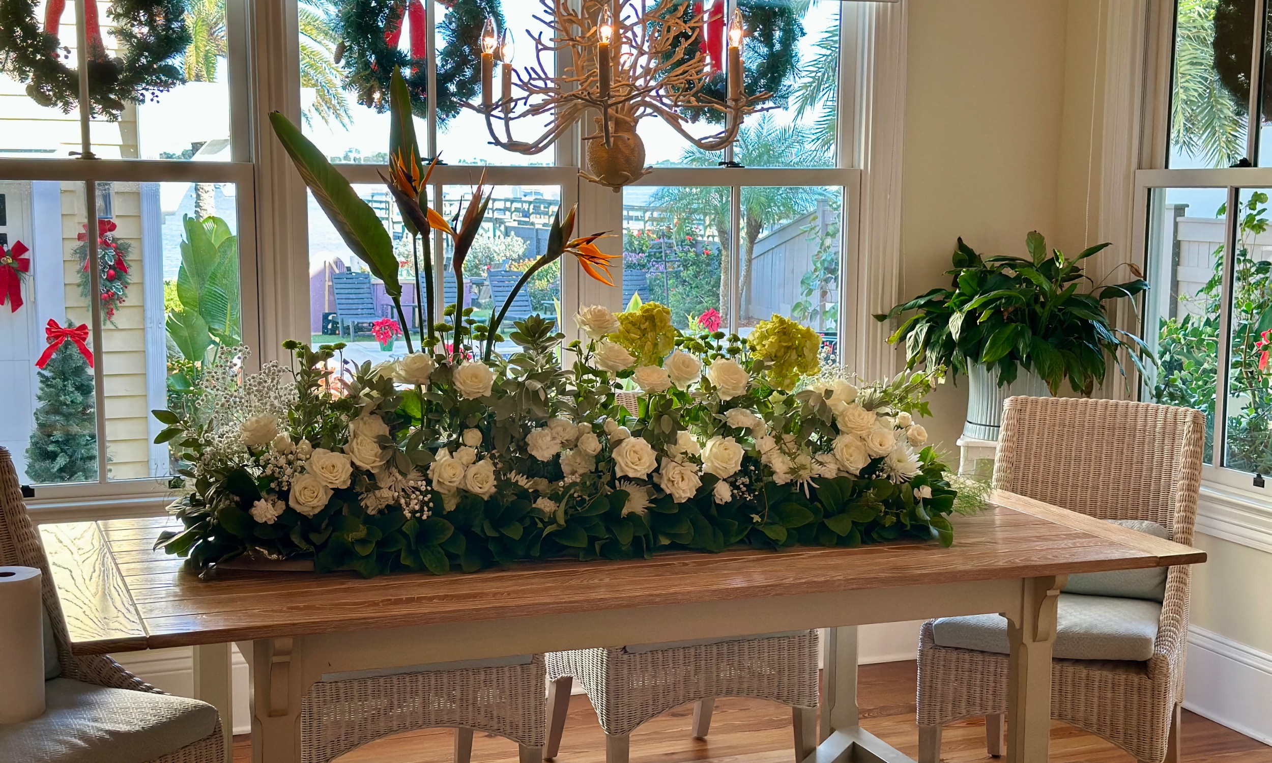 A dining nook is decorated with wreaths and a large table display for the Holiday Tour of Homes