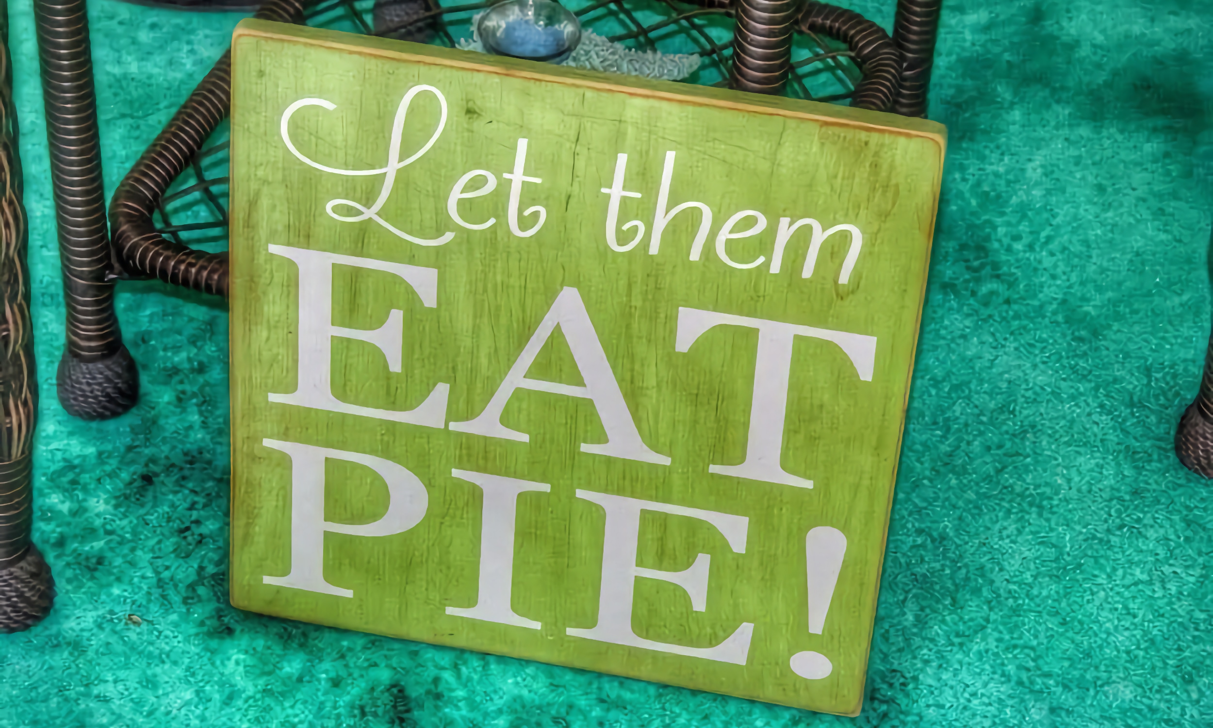 A green sign with white letters: "Let them eat pie!"