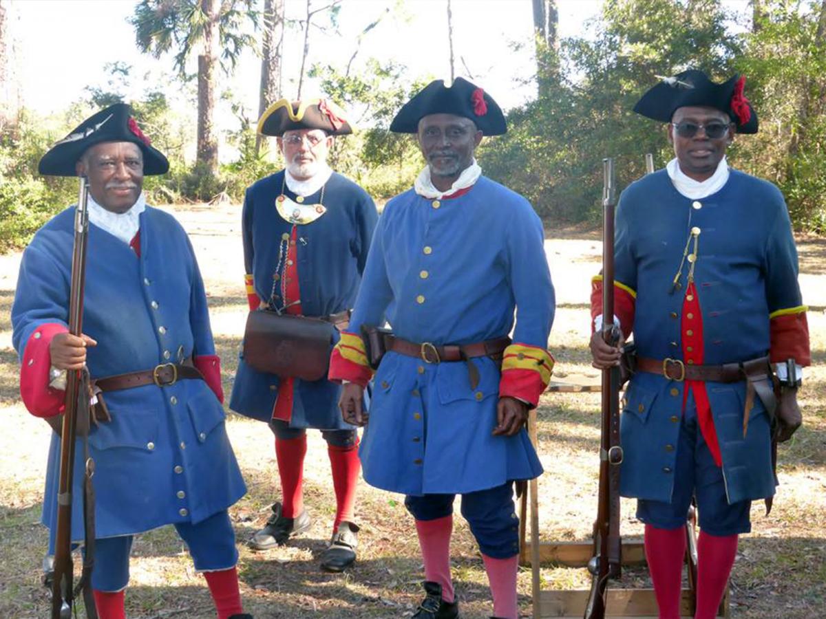 Members of the Fort Mose Historical Society dressed in the uniform of Spanish militiamen at Fort Mose Historic State Park in St. Augustine.