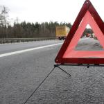 A warning triangle standing at the edge of a road to signal a slowdown ahead