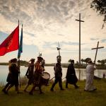 Seven men walk in a procession along the Matanzas River, dressed in the garb of colonial Spanish soldiers, citizens, and priests.