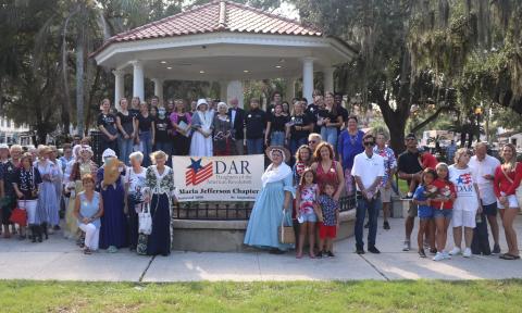 A gathering of local members of the Daughters of American Revolution, some in period costume, staged on and around the Gazebo in St. Augustine.