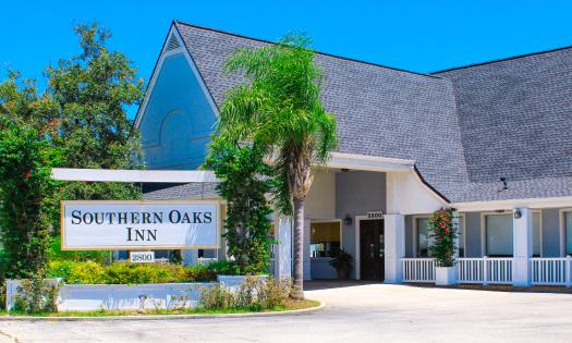 The entrance and sign for the Southern Oaks Inn, showing their entry porch and parking portico.