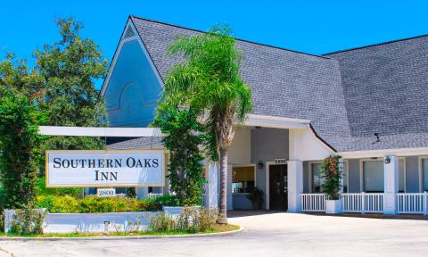 The entrance and sign for the Southern Oaks Inn, showing their entry porch and parking portico.