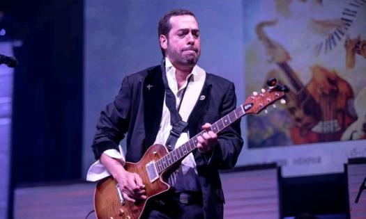 Albert Castiglia performs on stage with his guitar. 