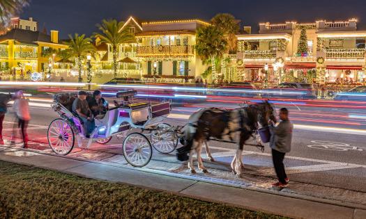 A photo taken by Mark Krancer of a horse and carriage in front a row of buildings with holiday lights