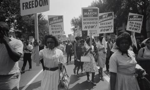 A group of women and men protest in the street. 