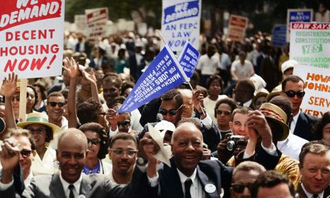 A group of men and women protest in the street. 